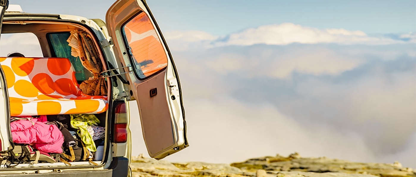 The back of a van. Doors open showing caming equipment