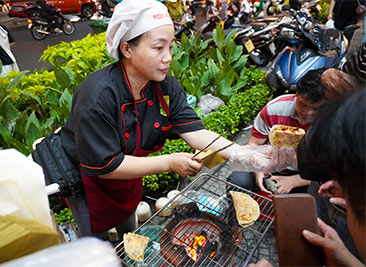 Vietnamese woman serves street food