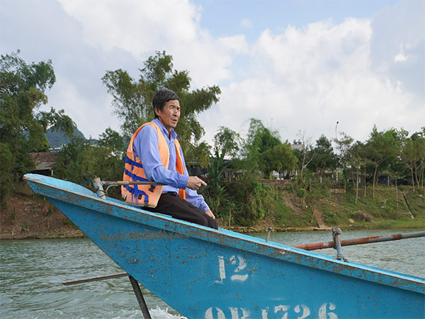 Vietnamese man sits in boat at Phong Nha Cave